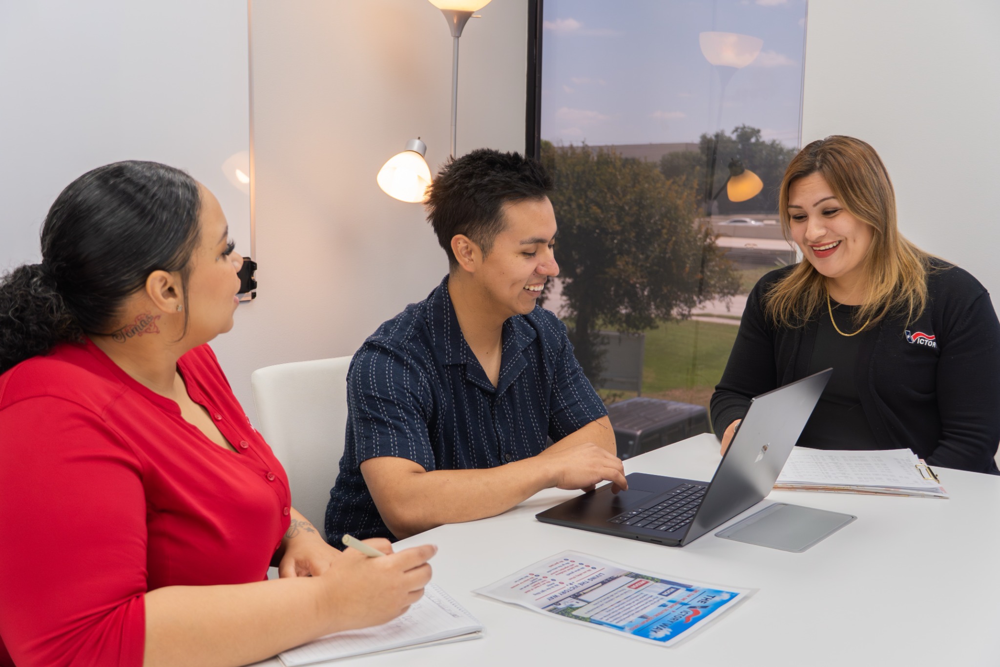 Victory office team members collaborating around a laptop